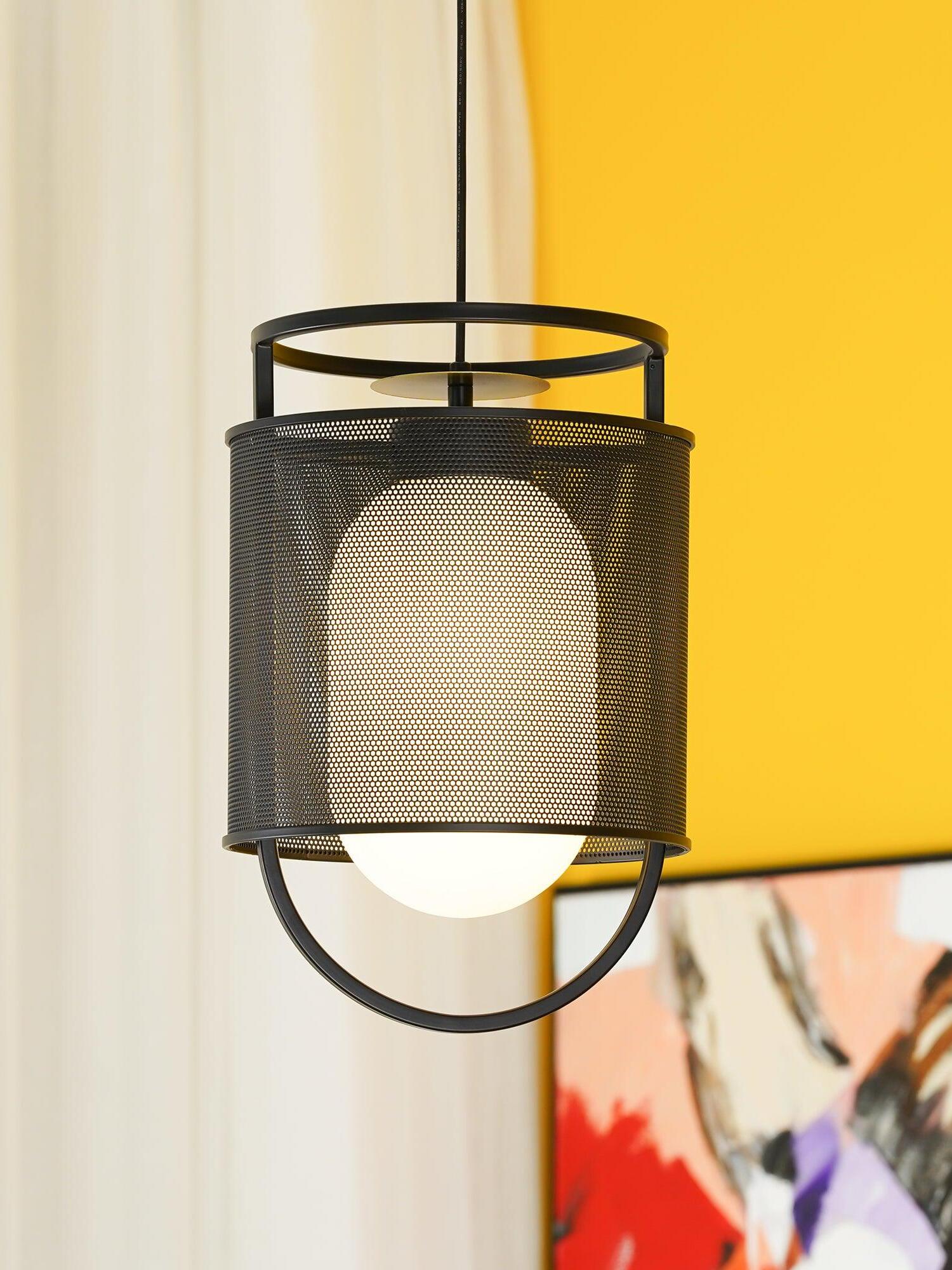 Black mesh pendant before yellow and white wall
