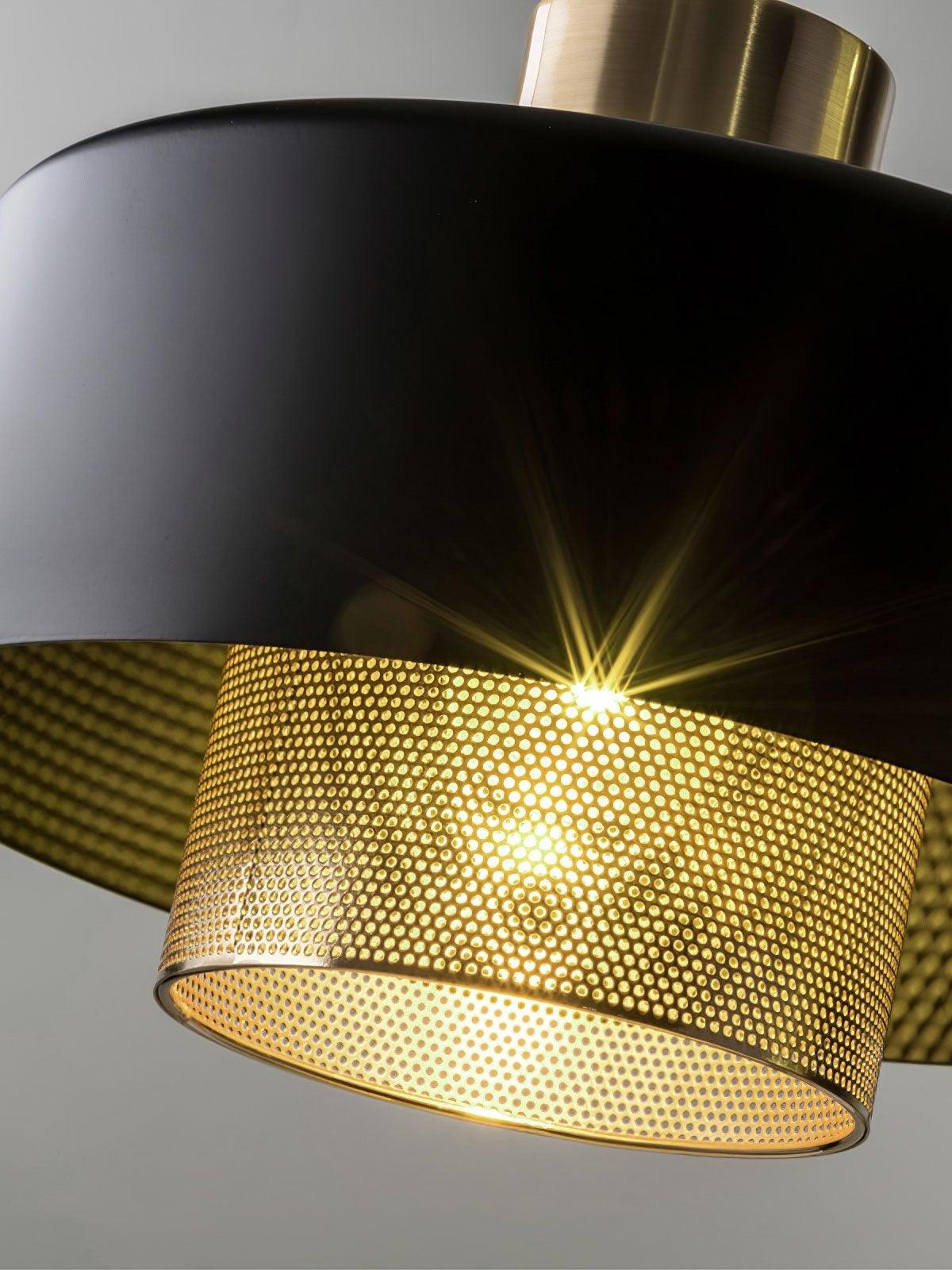 Close lit Bradbury pendant showing smooth black outer metal and the perforated copper-tone inner cylinder