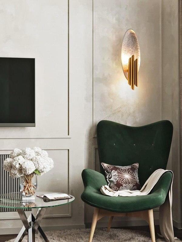 Silver-tone oval and gold tubes above green armchair