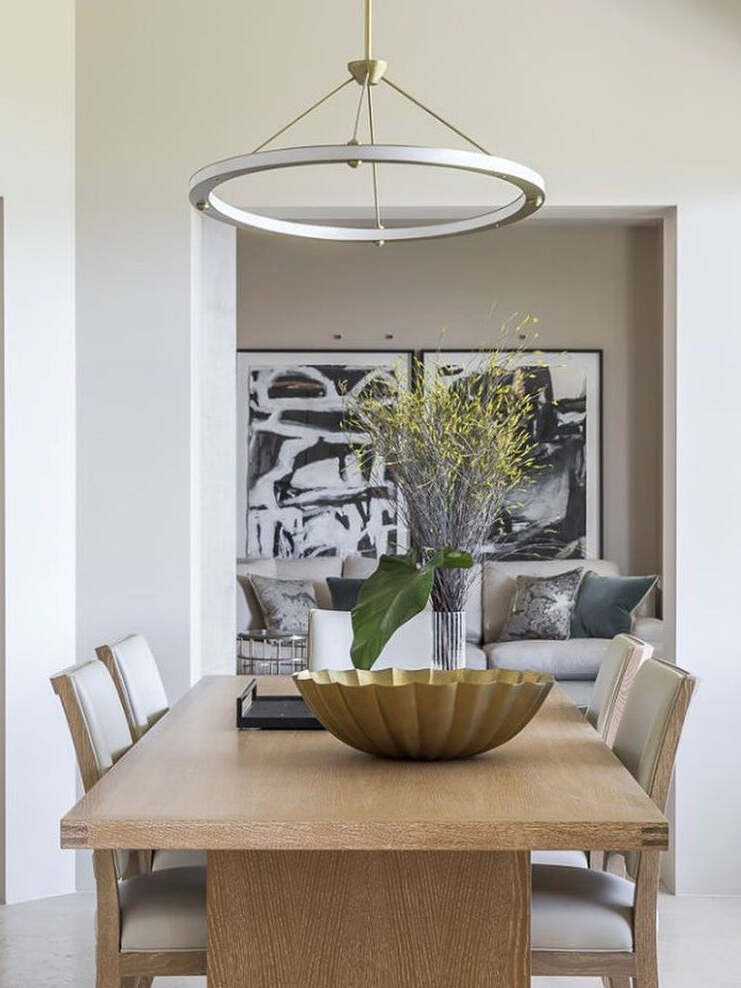 Gold ring pendant above a wooden dining table