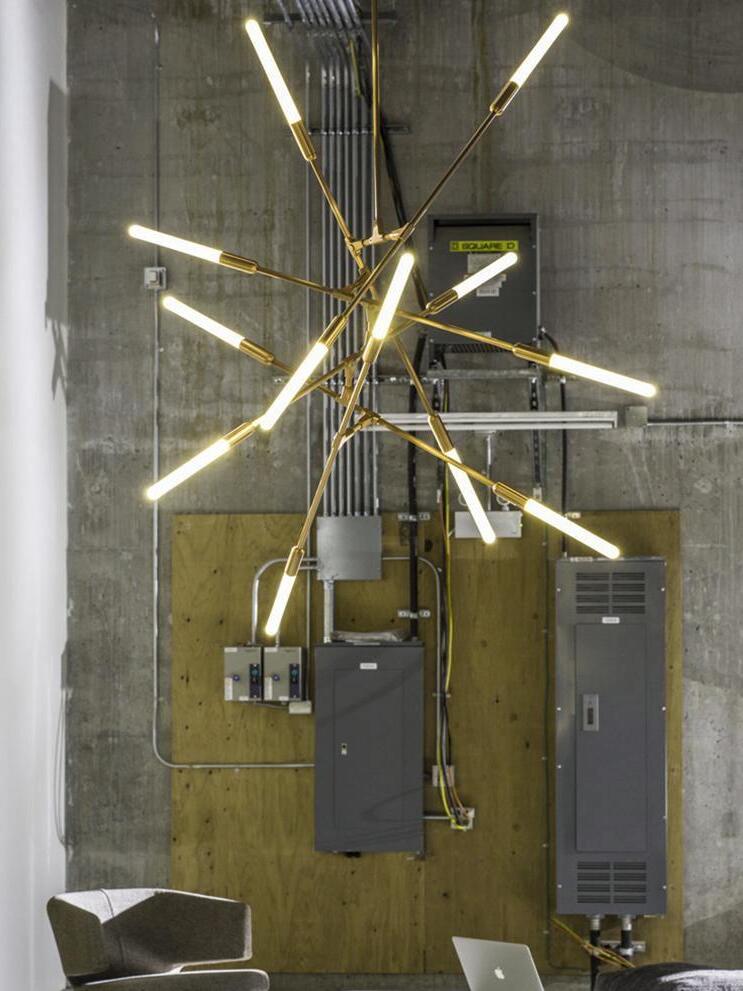 Vertical chandelier against a tall dark wall