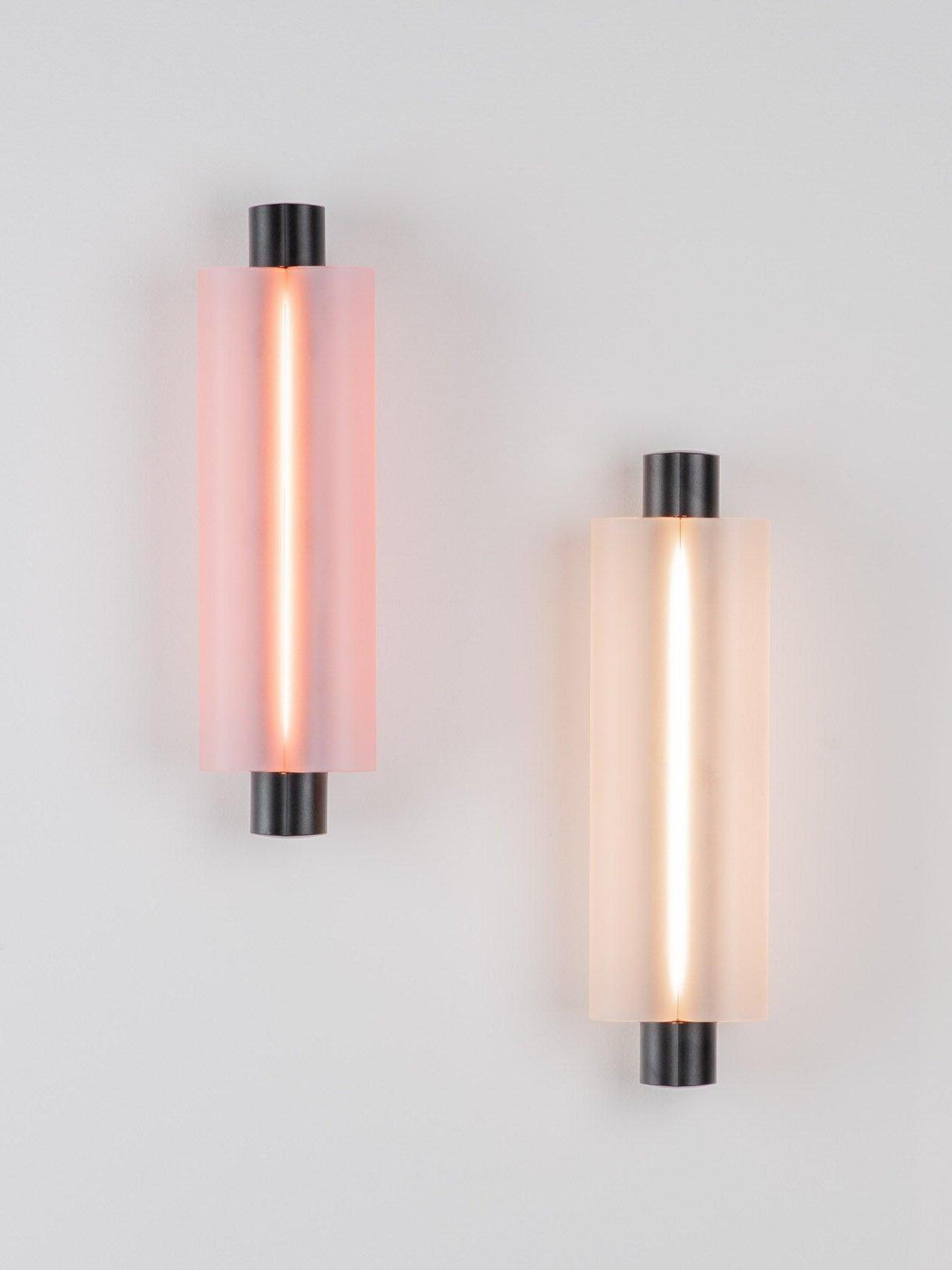 Two black-ended wall fixtures with red and pale illumination