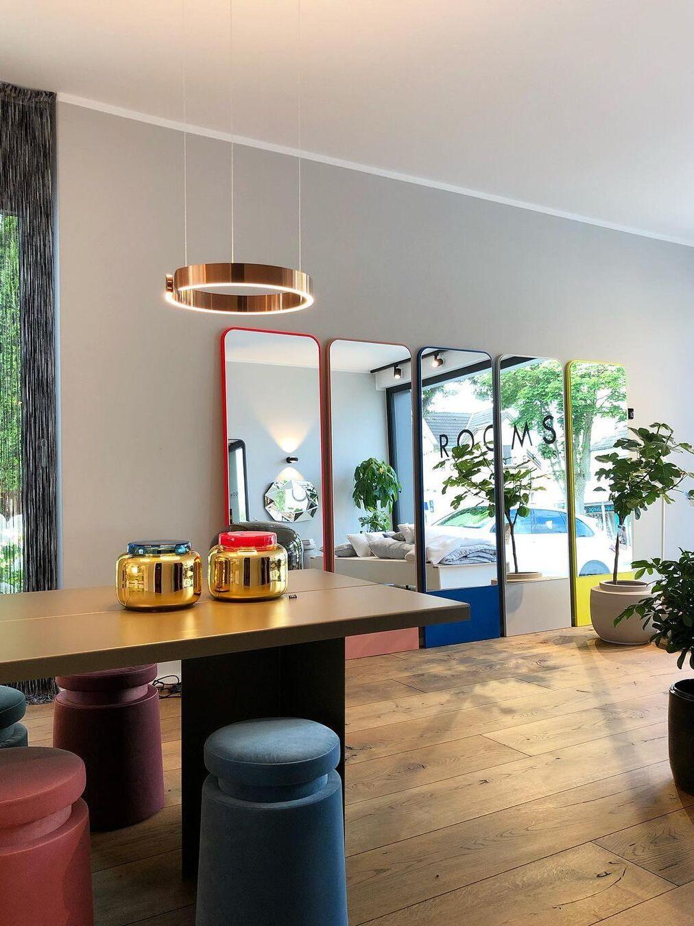 Rose-gold-coloured ring above a table and stools