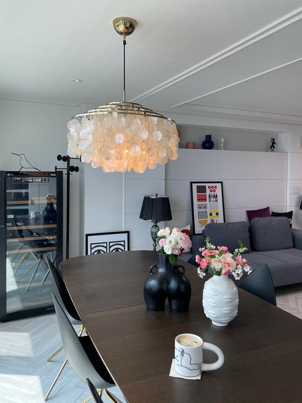Glowing shell pendant above flowers on a table