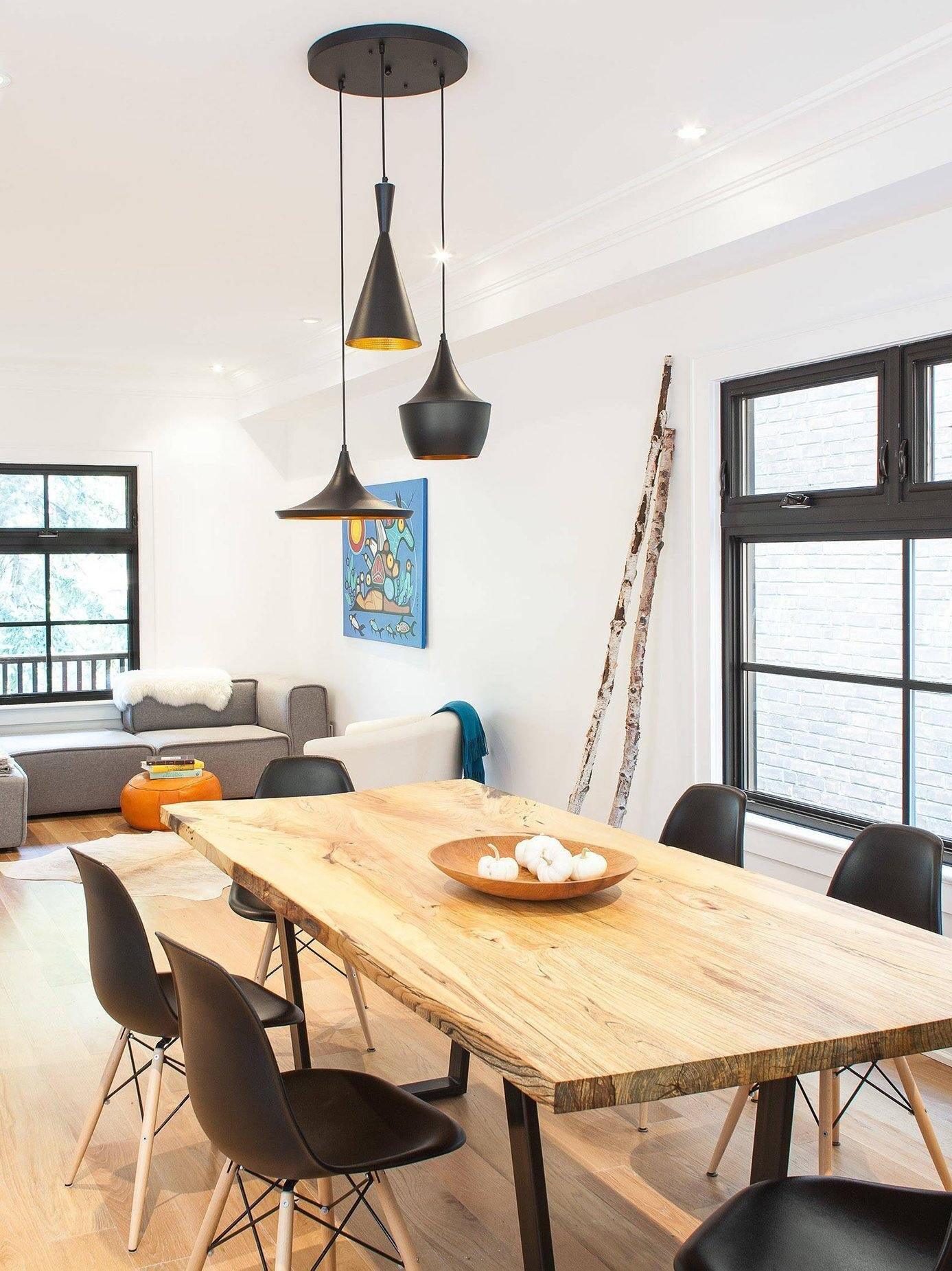 Three black pendant shapes above a wood table