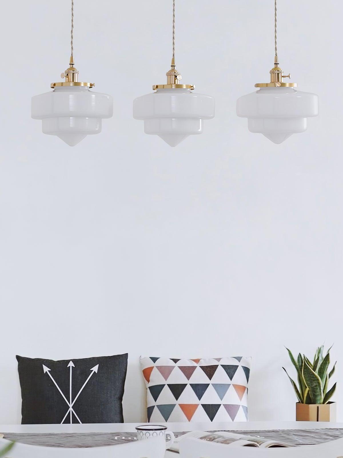 Three Atlas Model A shades at an even height above a table and bench with arrow and triangle-patterned cushions