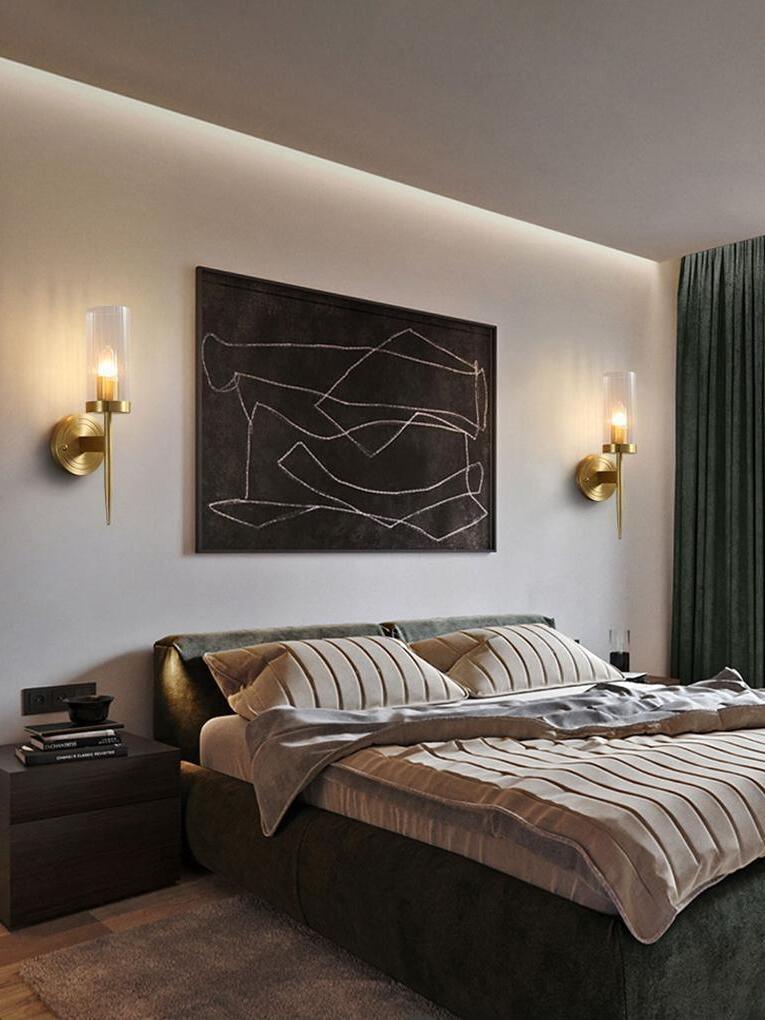 Separate candle-style sconces flanking bedroom wall art