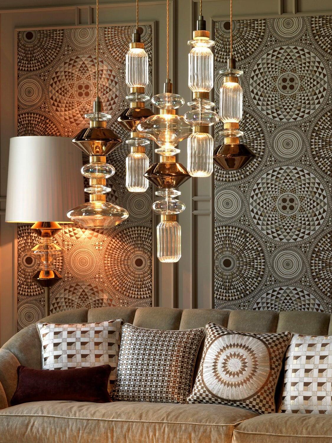 Mixed glass pendants above patterned living-room seating