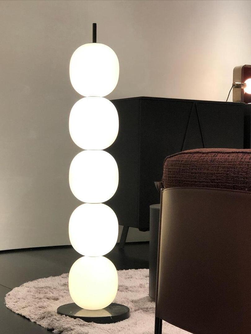 Glowing globe lamp next to dark armchair