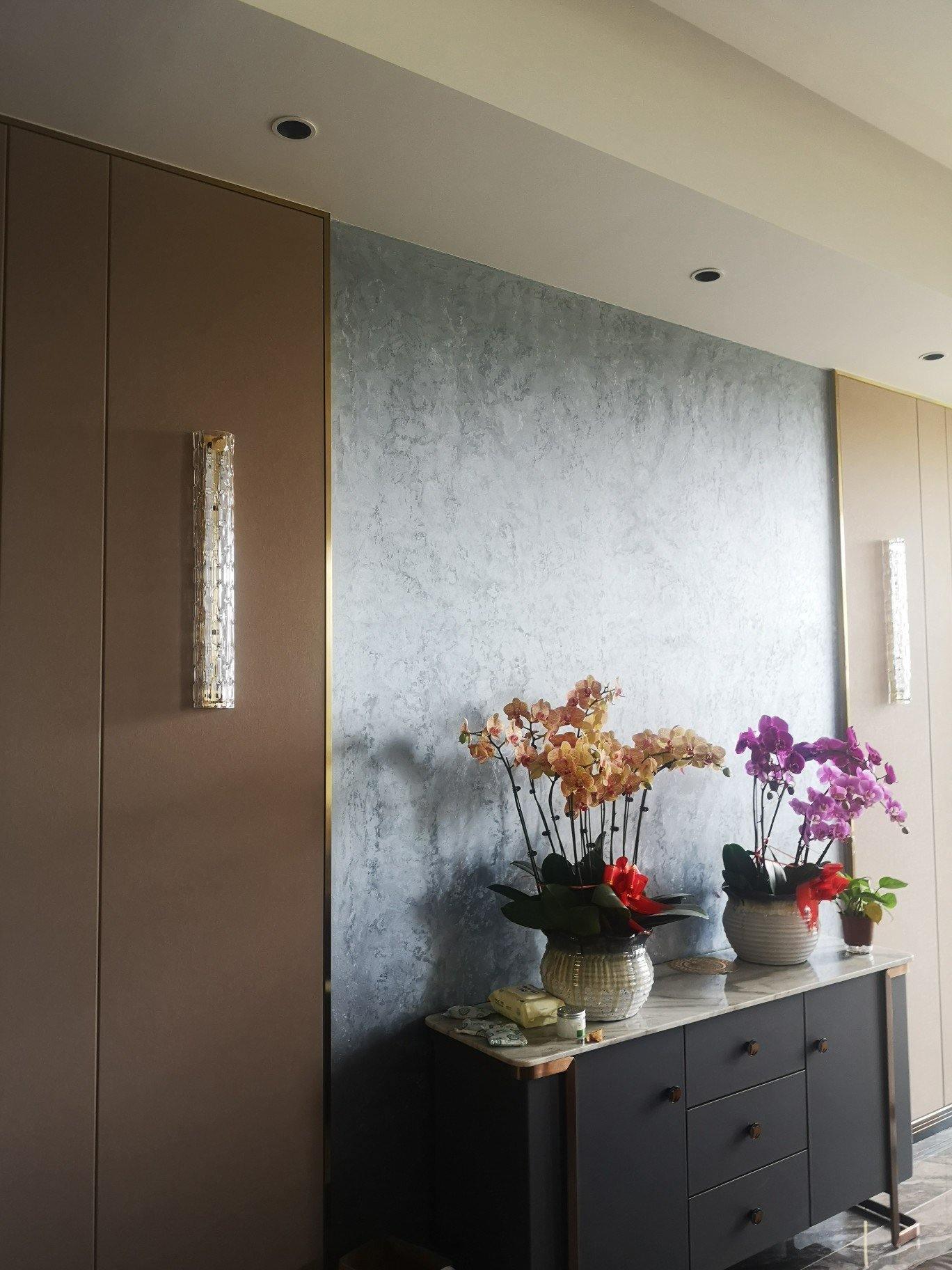 Two unlit glass wall bars flanking console and flowers