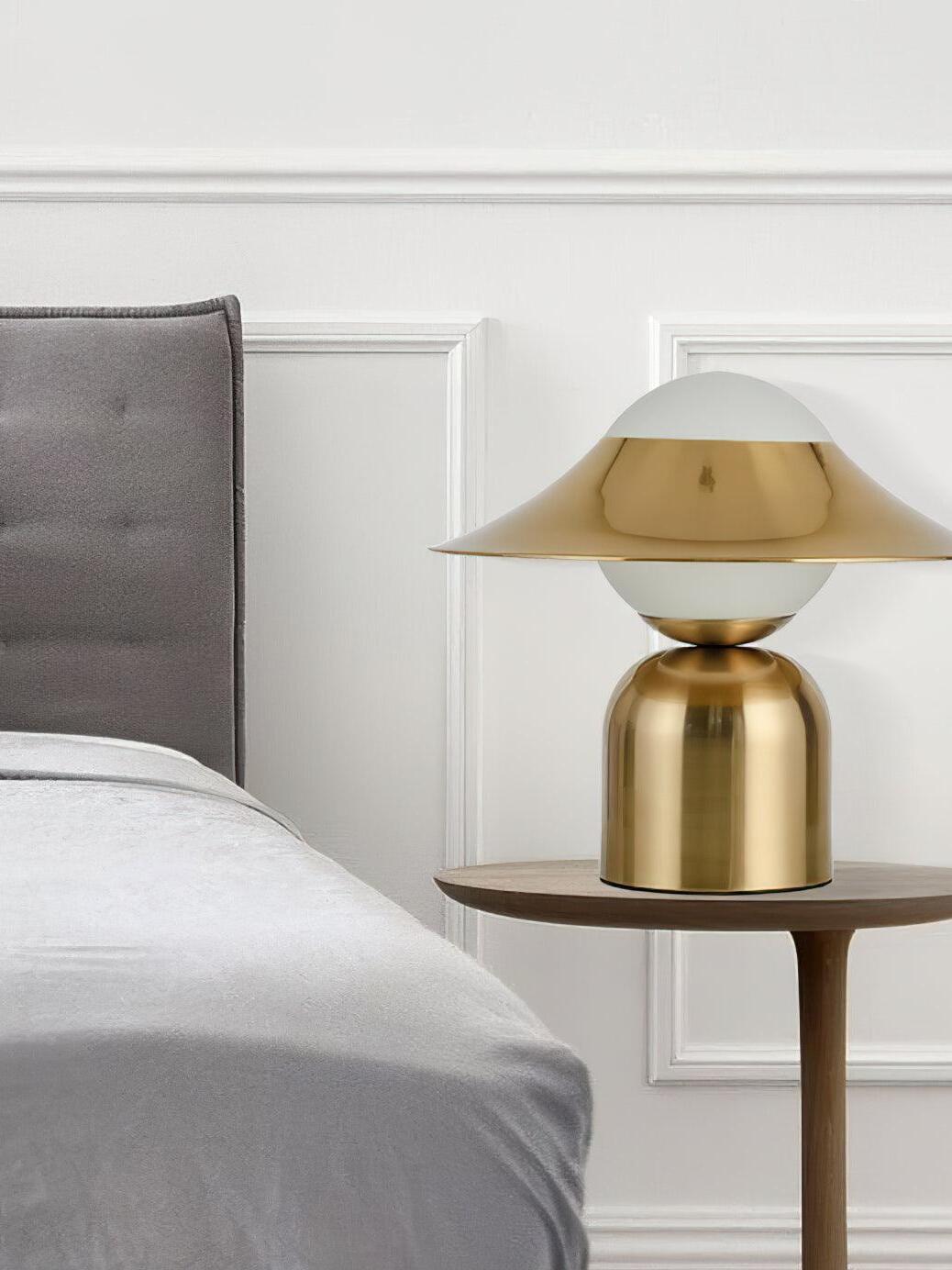 Gold and white disc lamp on bedside table