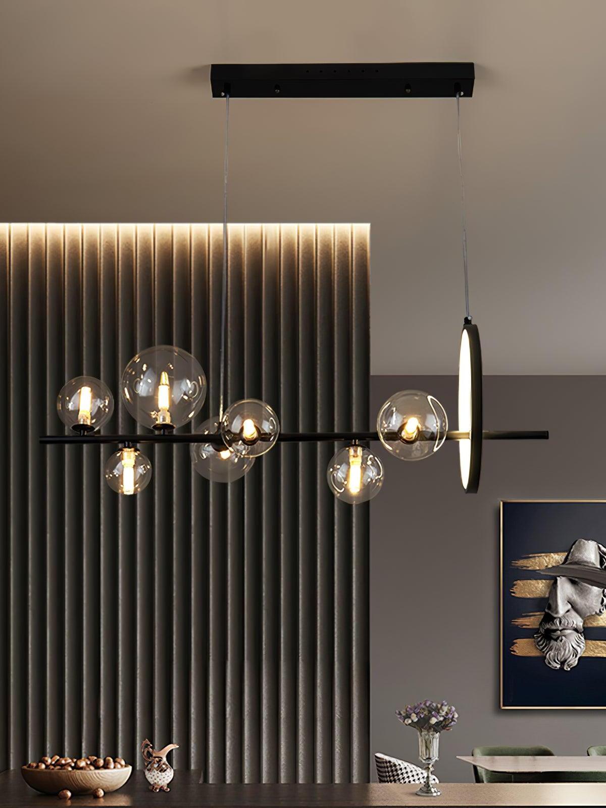 Linear chandelier above a dining table and ribbed wall