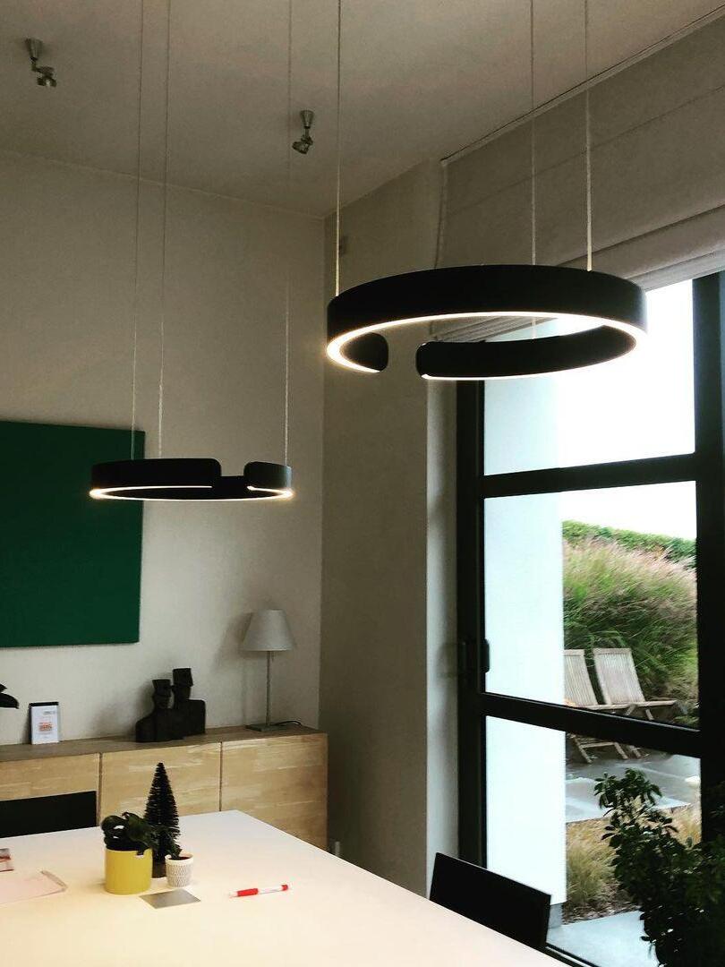 Black ring pendants beside a tall window