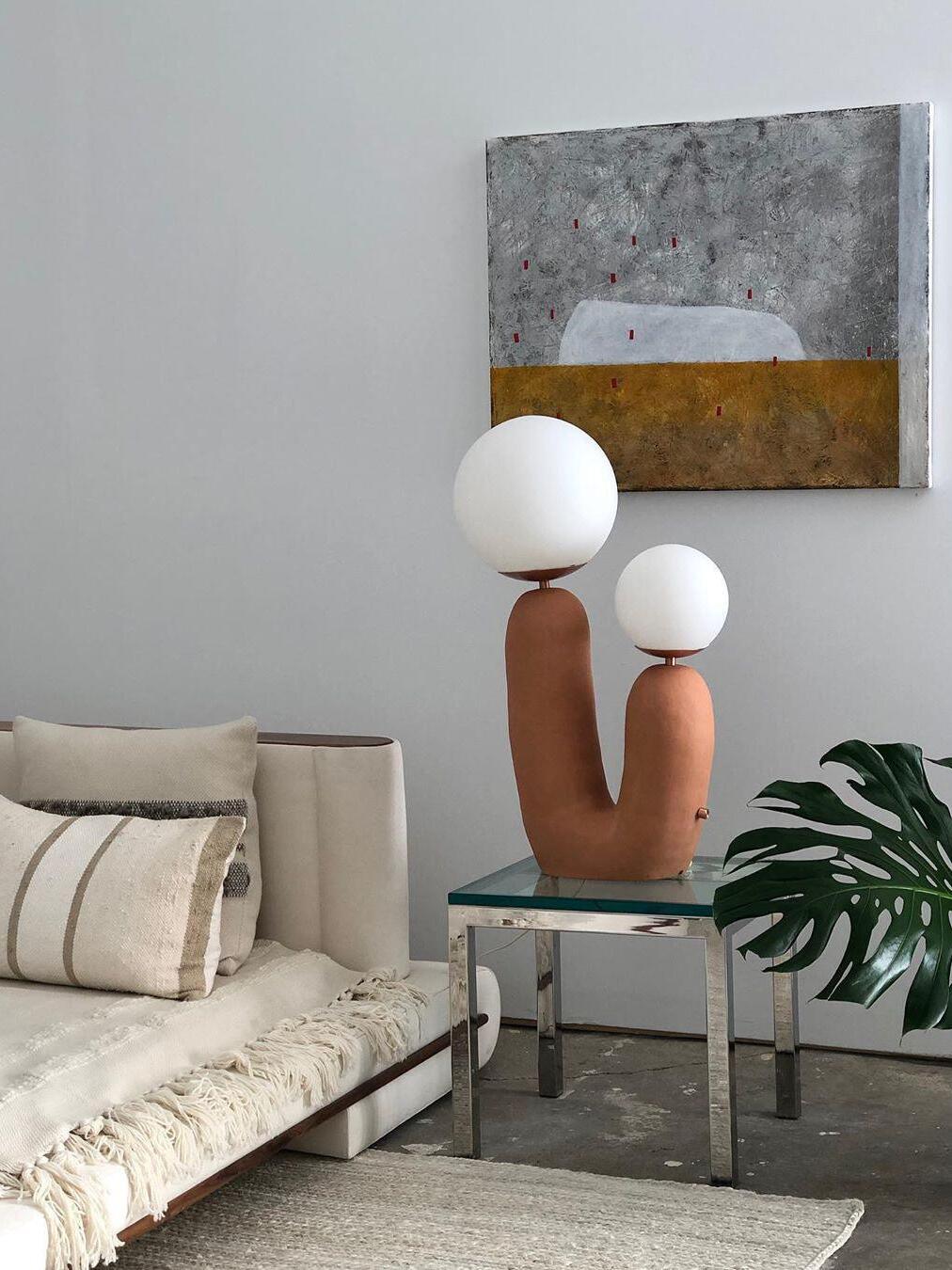 Terracotta-toned double-globe lamp on a side table