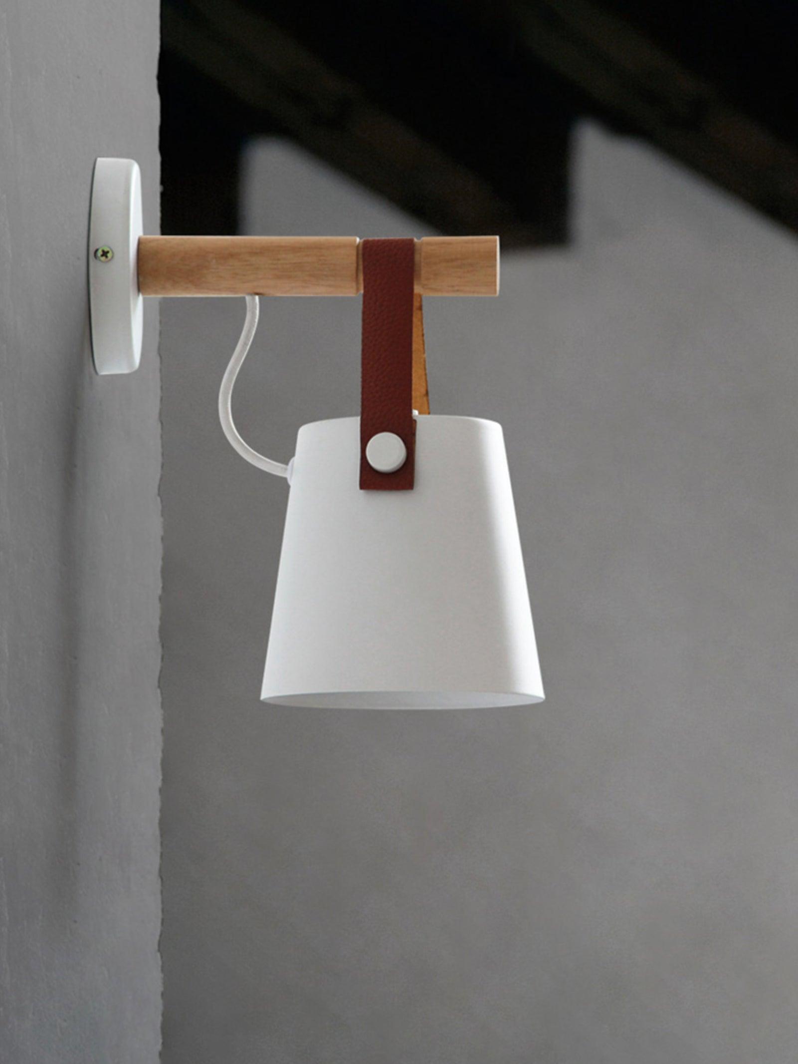 White shade, brown strap and curved cable below a wooden bar