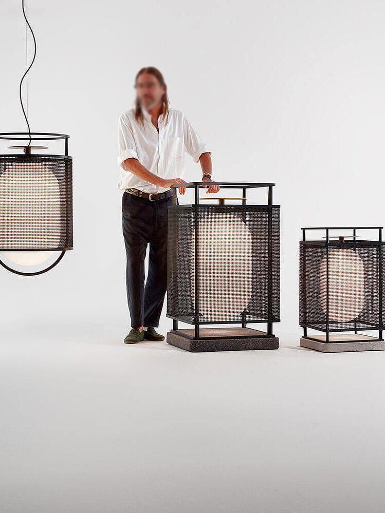 Person beside hanging lantern and floor-standing lights