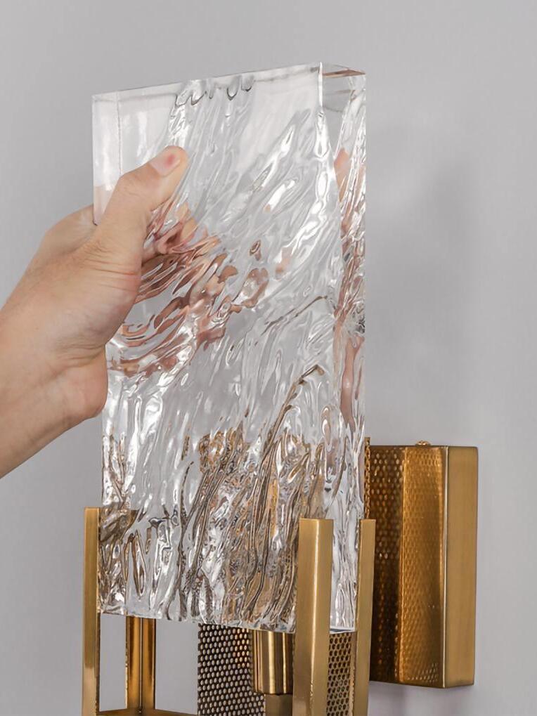Hand holding textured glass panel above the wall-light frame