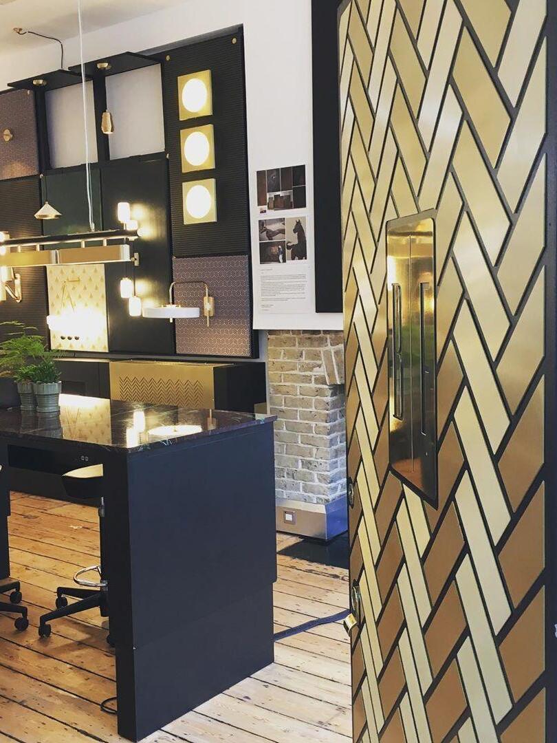 Colt pendant cropped above a showroom desk, with other wall and ceiling fixtures displayed around it