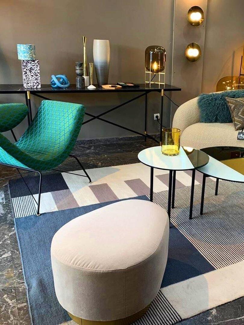 Amber glass lamp among colourful seating and occasional tables.