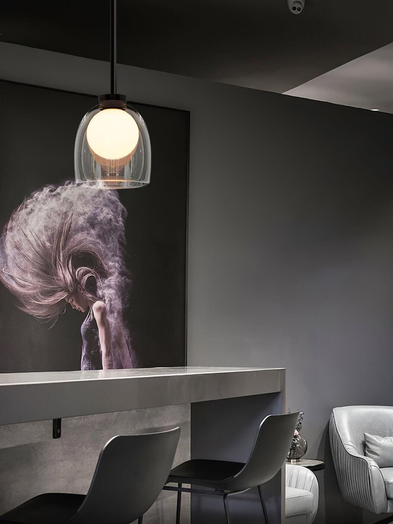 Clear Crux pendant above dining furniture beside a large wall artwork