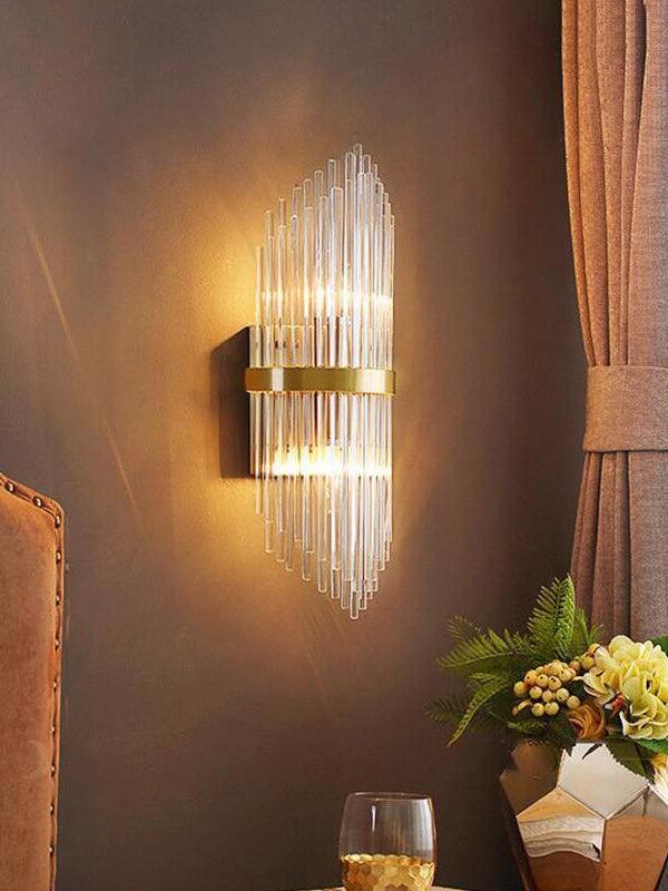 Lit crystal rod wall sconce beside curtain and flowers