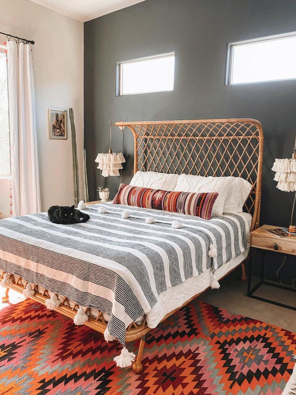 White tassel wall light beside a patterned bed