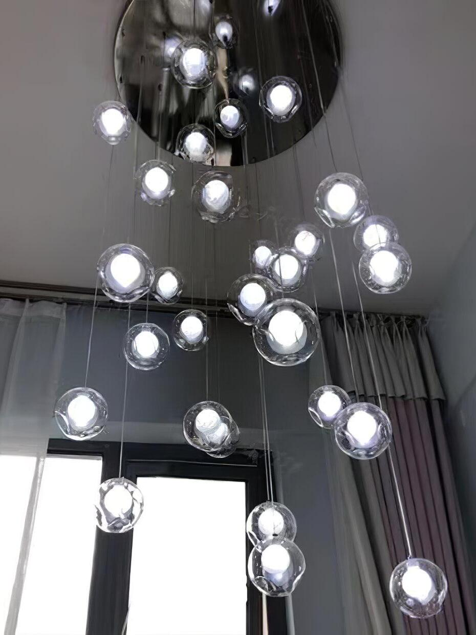 Chrome round ceiling plate above glowing glass globes
