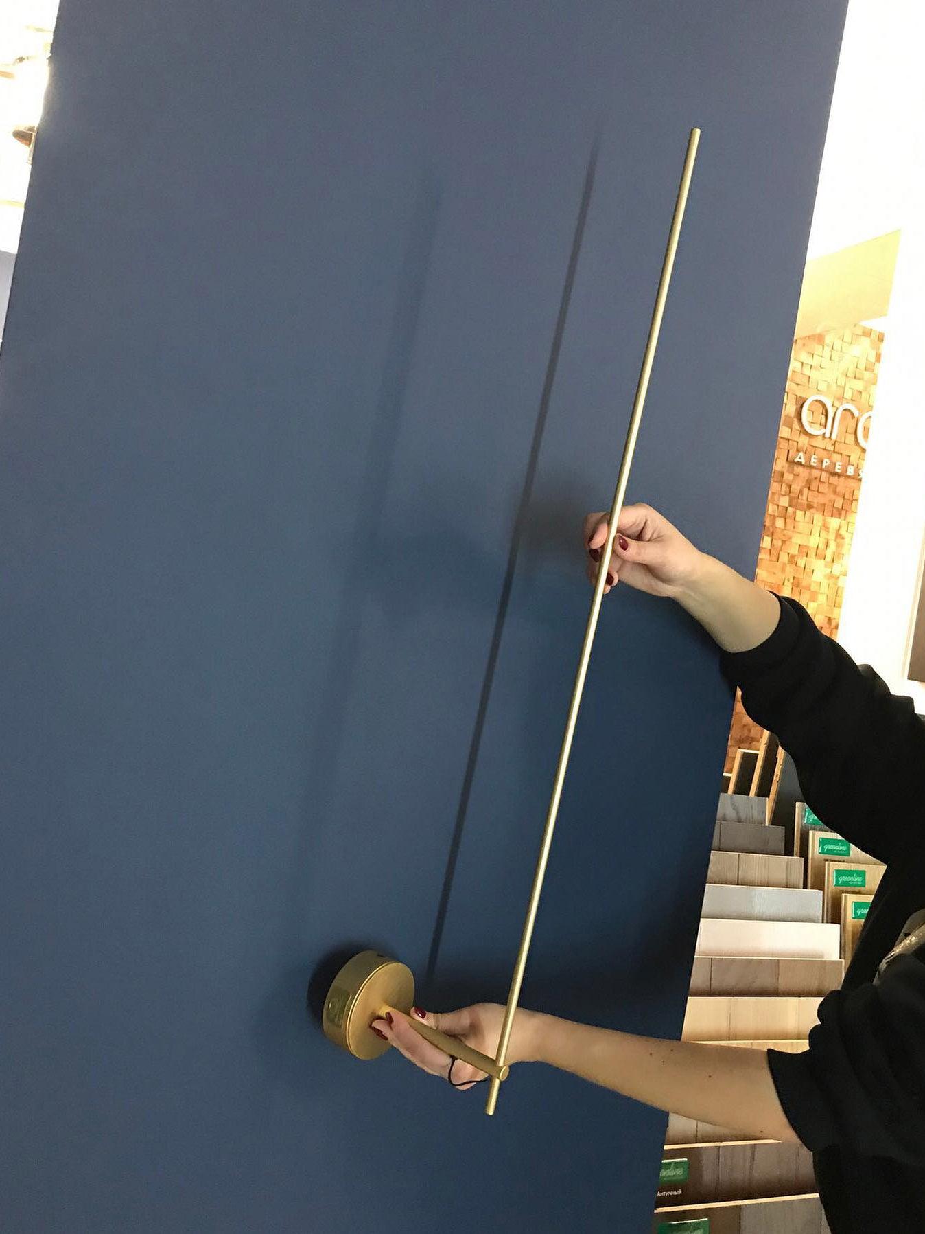 Hands demonstrating the rod and wall-plate assembly