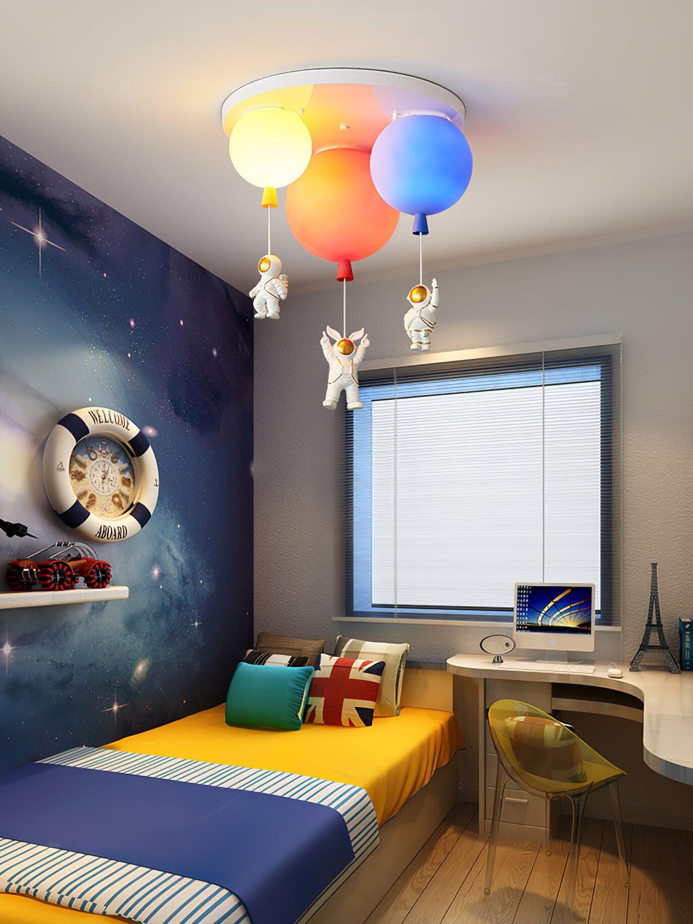 Three coloured balloon lights above a striped bed