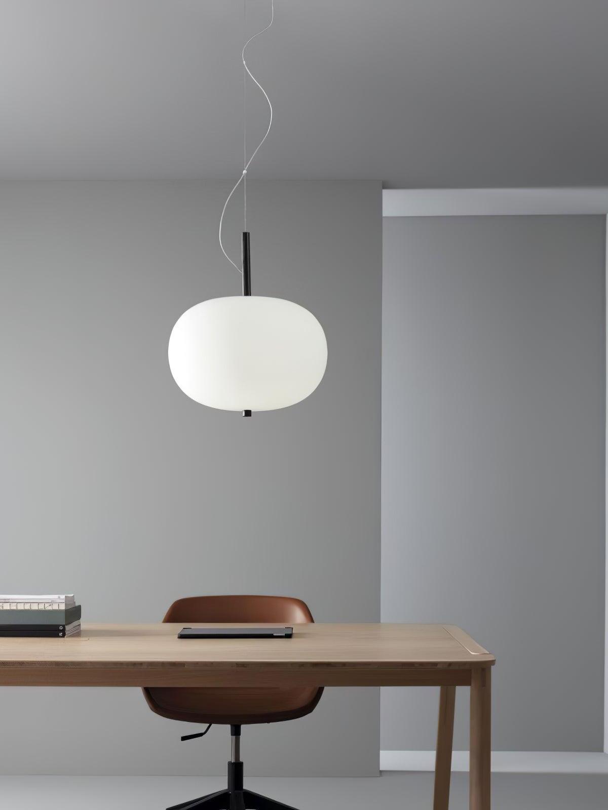 Single white globe pendant above a wooden desk
