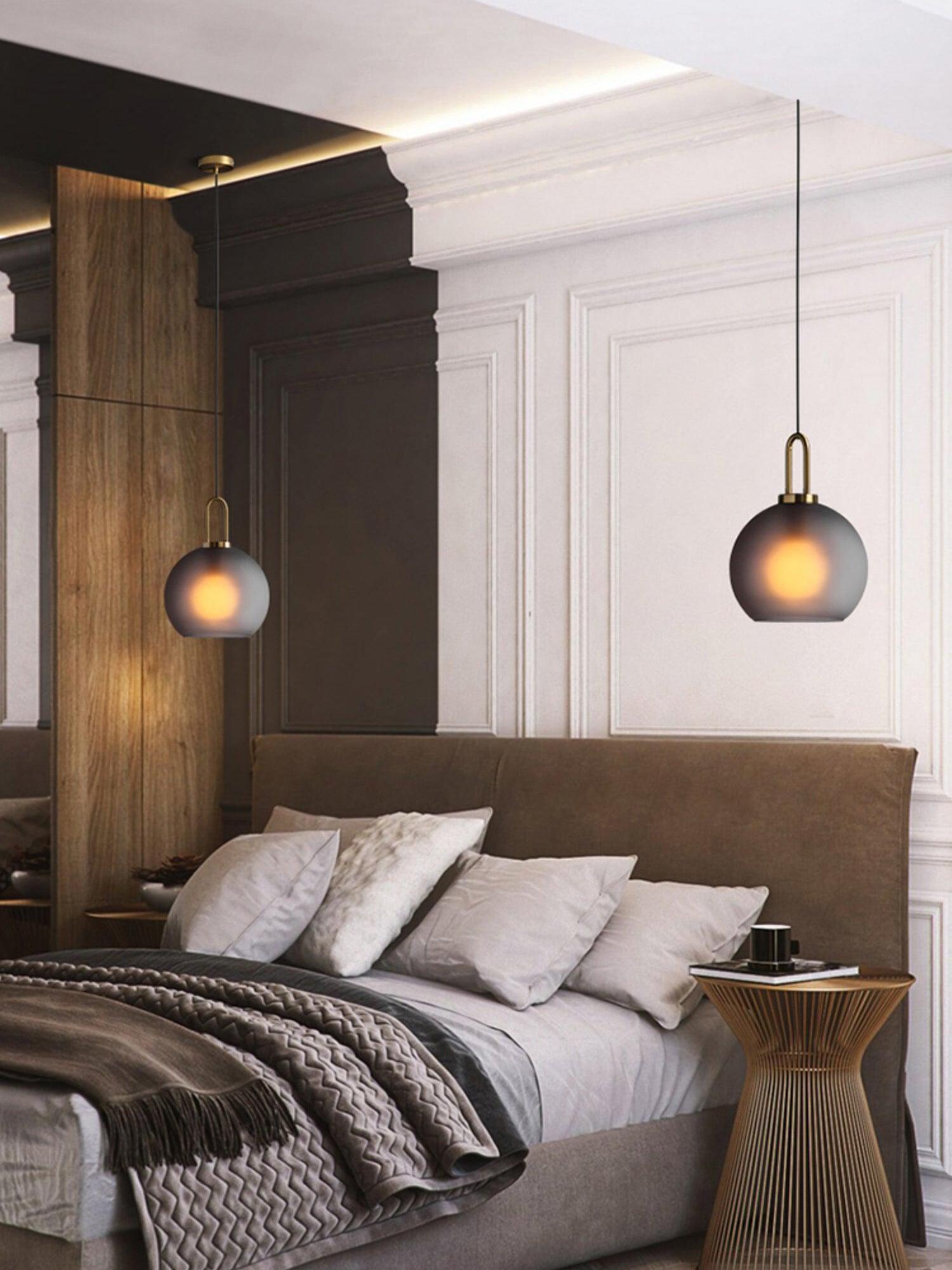Two frosted globe pendants above a bed