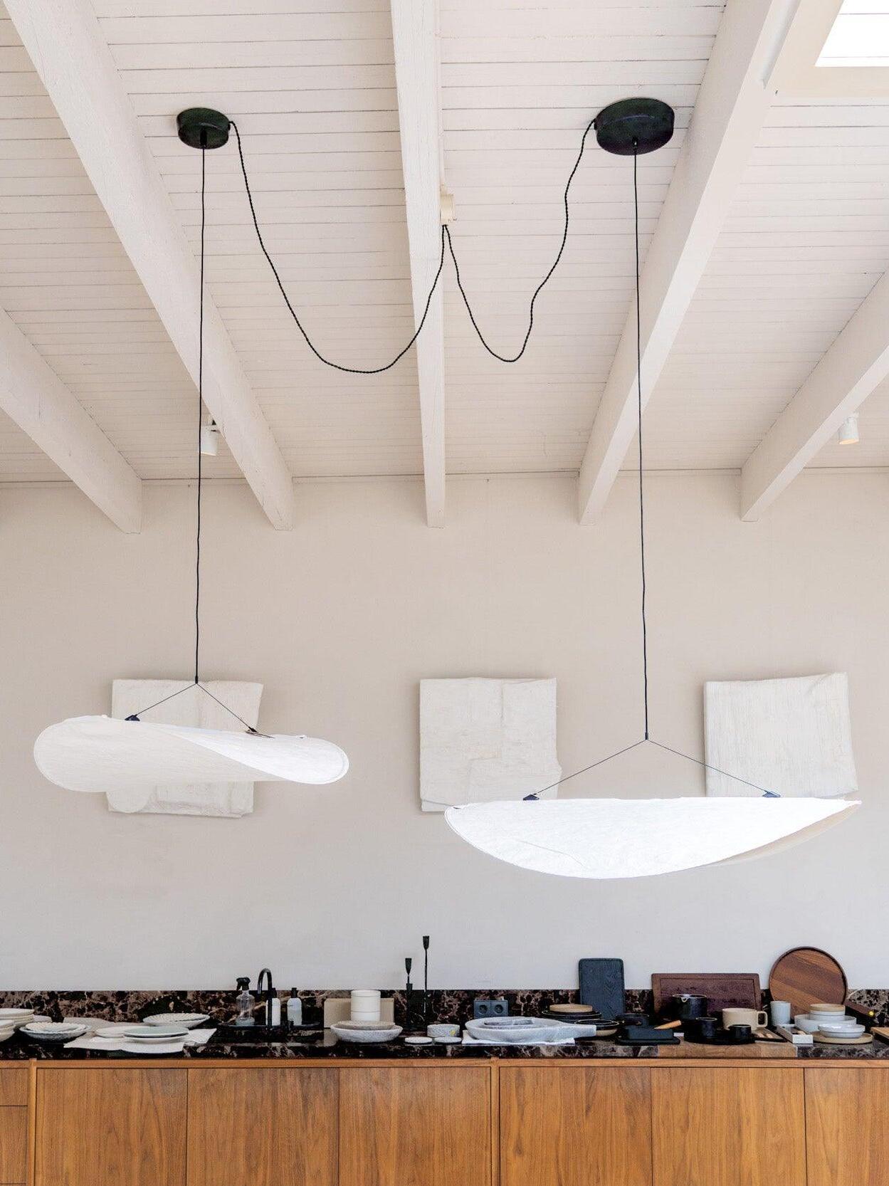 Two white pendants beneath exposed ceiling beams