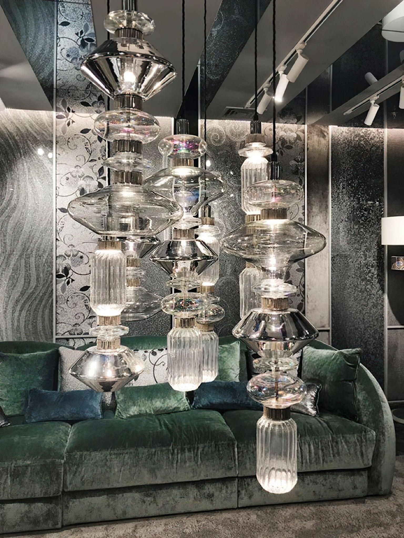 Close cluster of glass pendants before green upholstery
