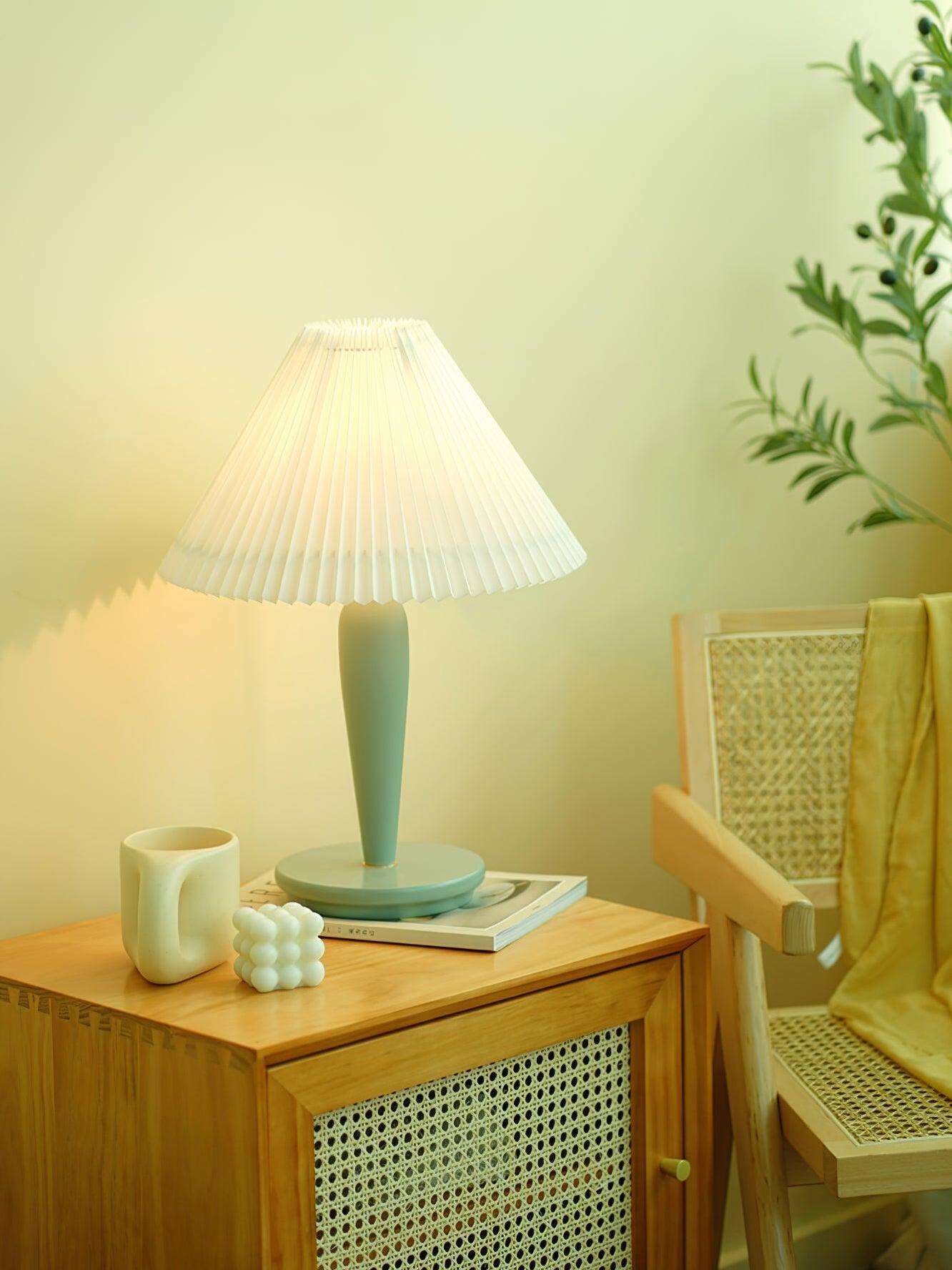 Light-blue table lamp on cane-front table near chair