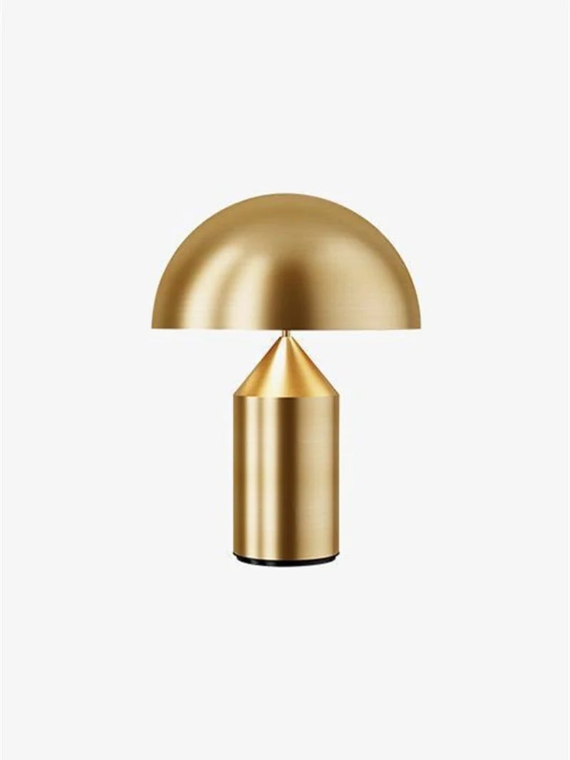 Isolated gold-tone dome table lamp above a cone-topped cylindrical base
