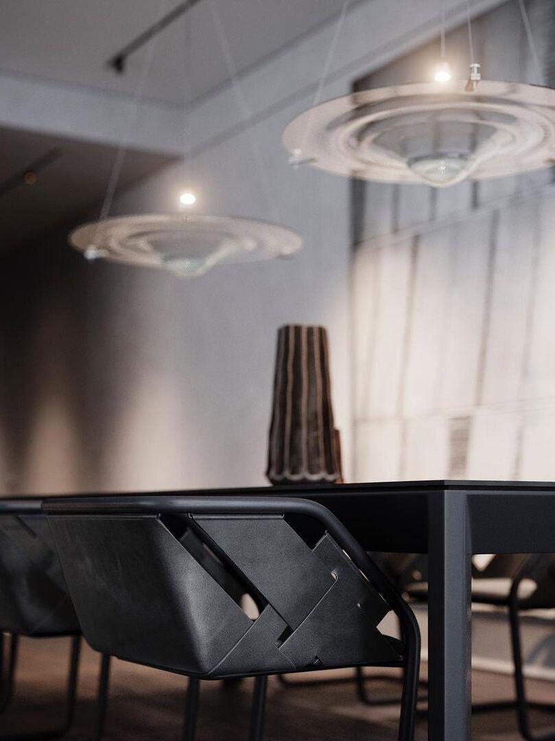 Clear disc pendants above dark dining table