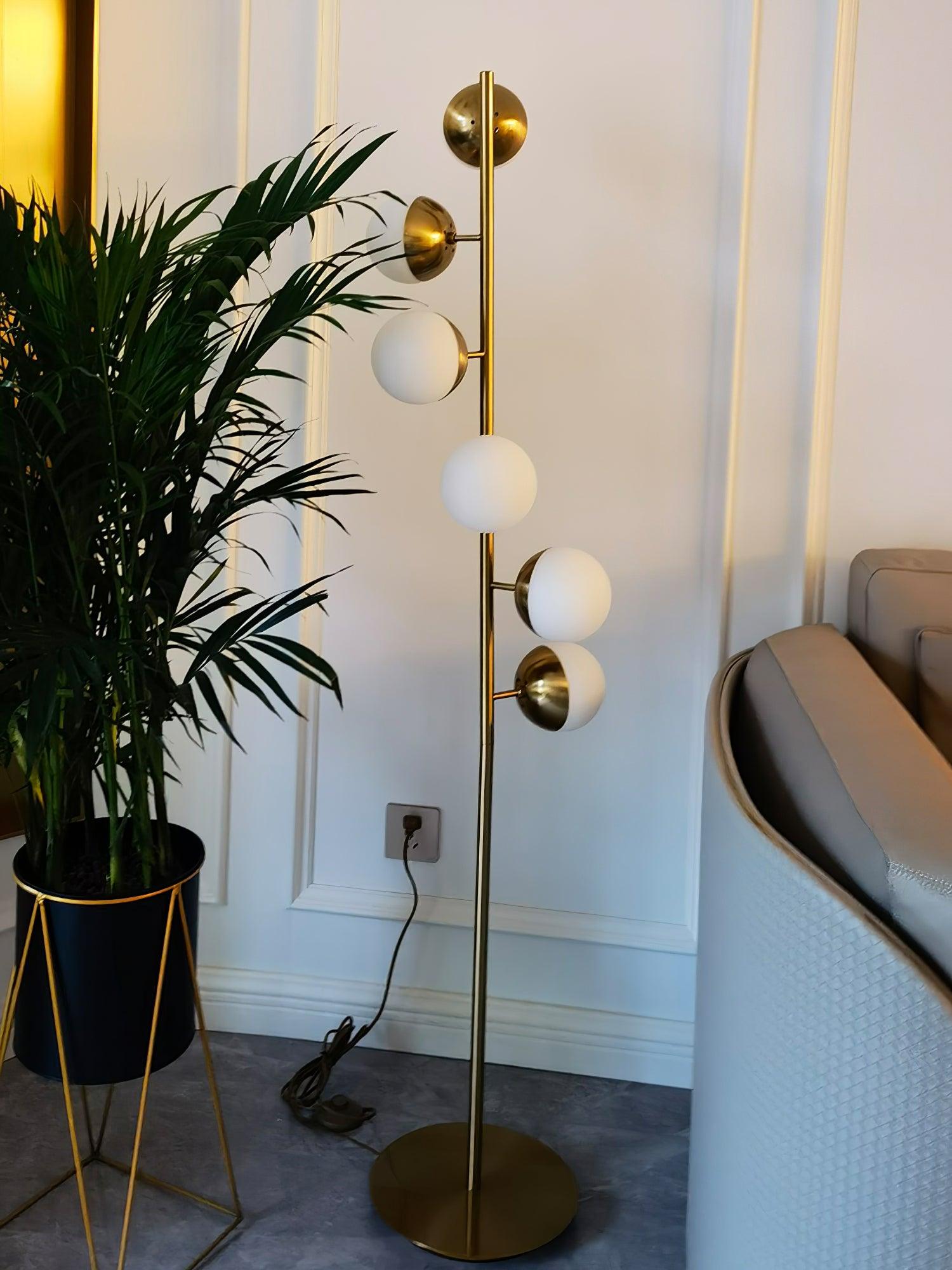 Tall lamp by plant and visible wall outlet