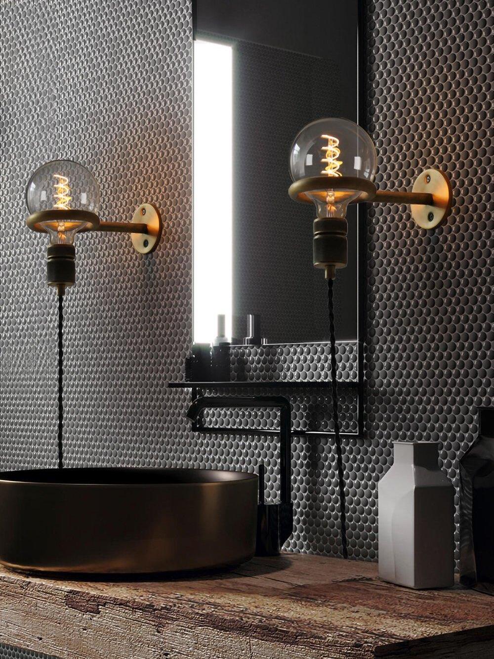 Paired upward-facing globe fixtures beside mirror above basin