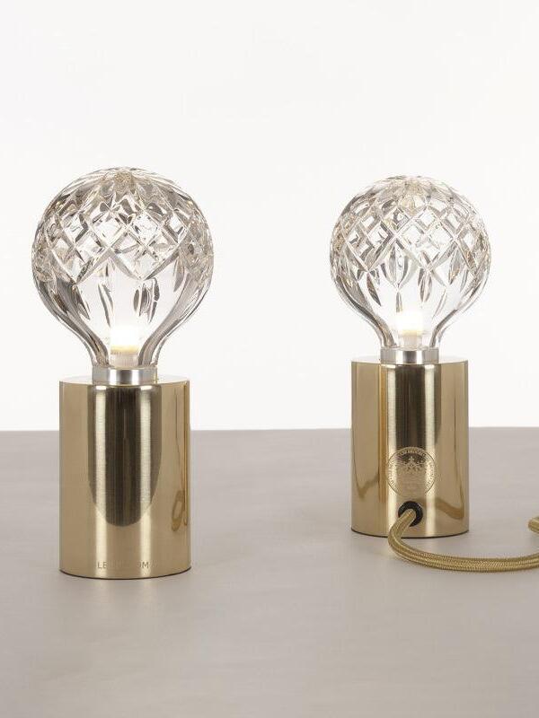 Two clear globe table lamps with polished gold-tone bases and cord