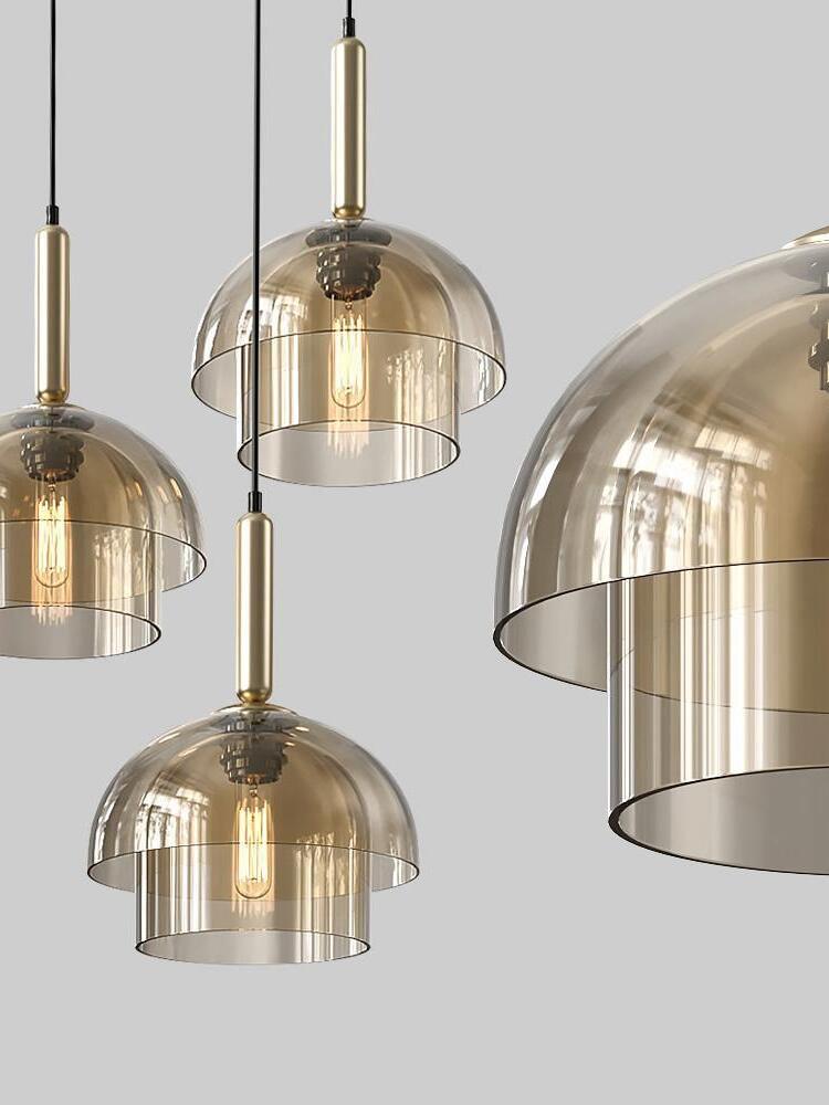 Several two-tier glass pendants on grey, with gold-tone fittings, visible filament bulbs and one large cropped shade at right