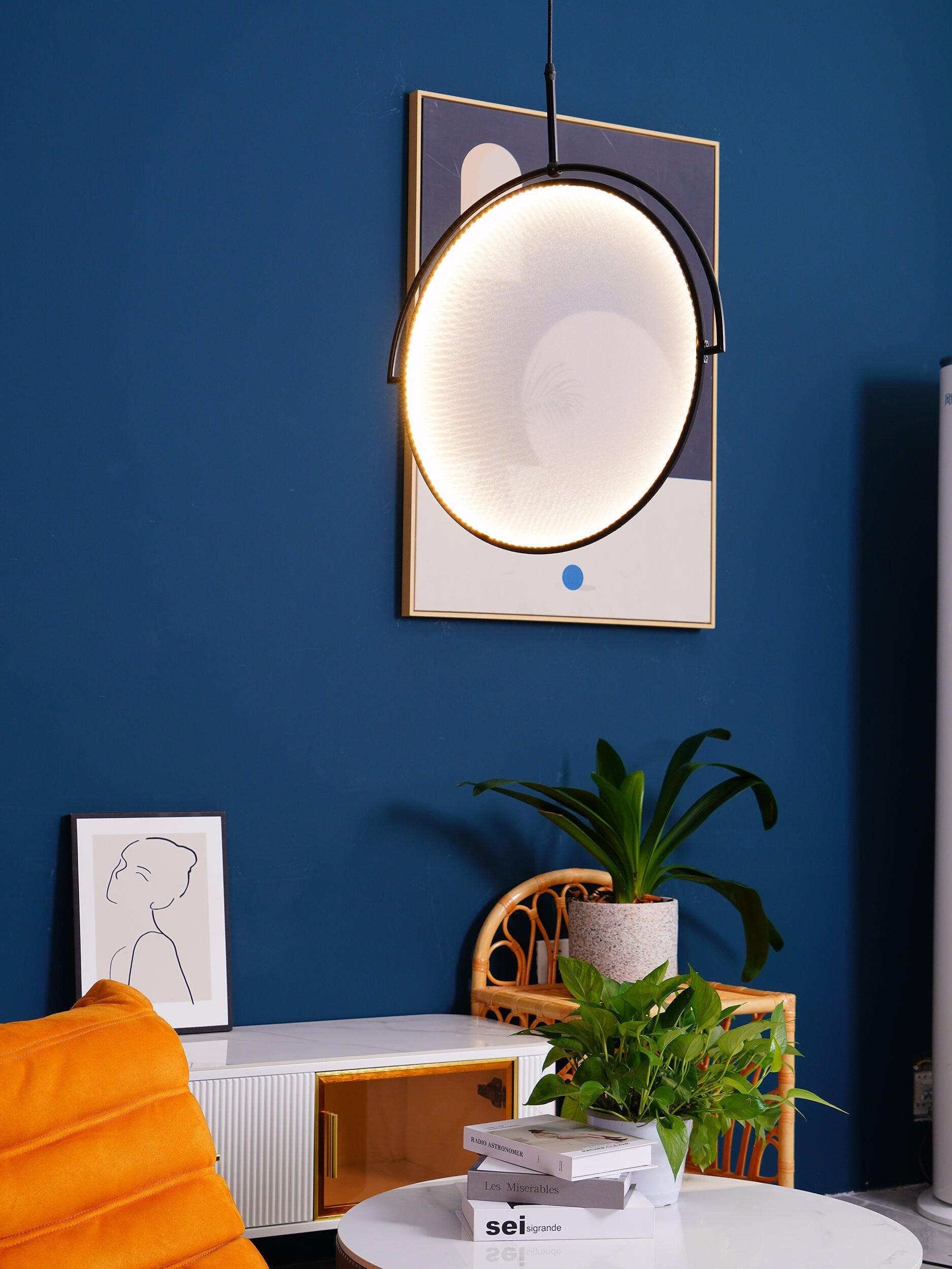 Tilted circular pendant above a chair and side table