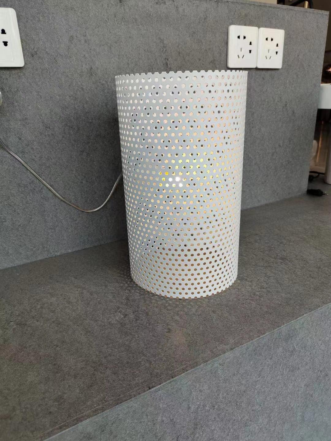 Detail of white perforated cylindrical lamp base