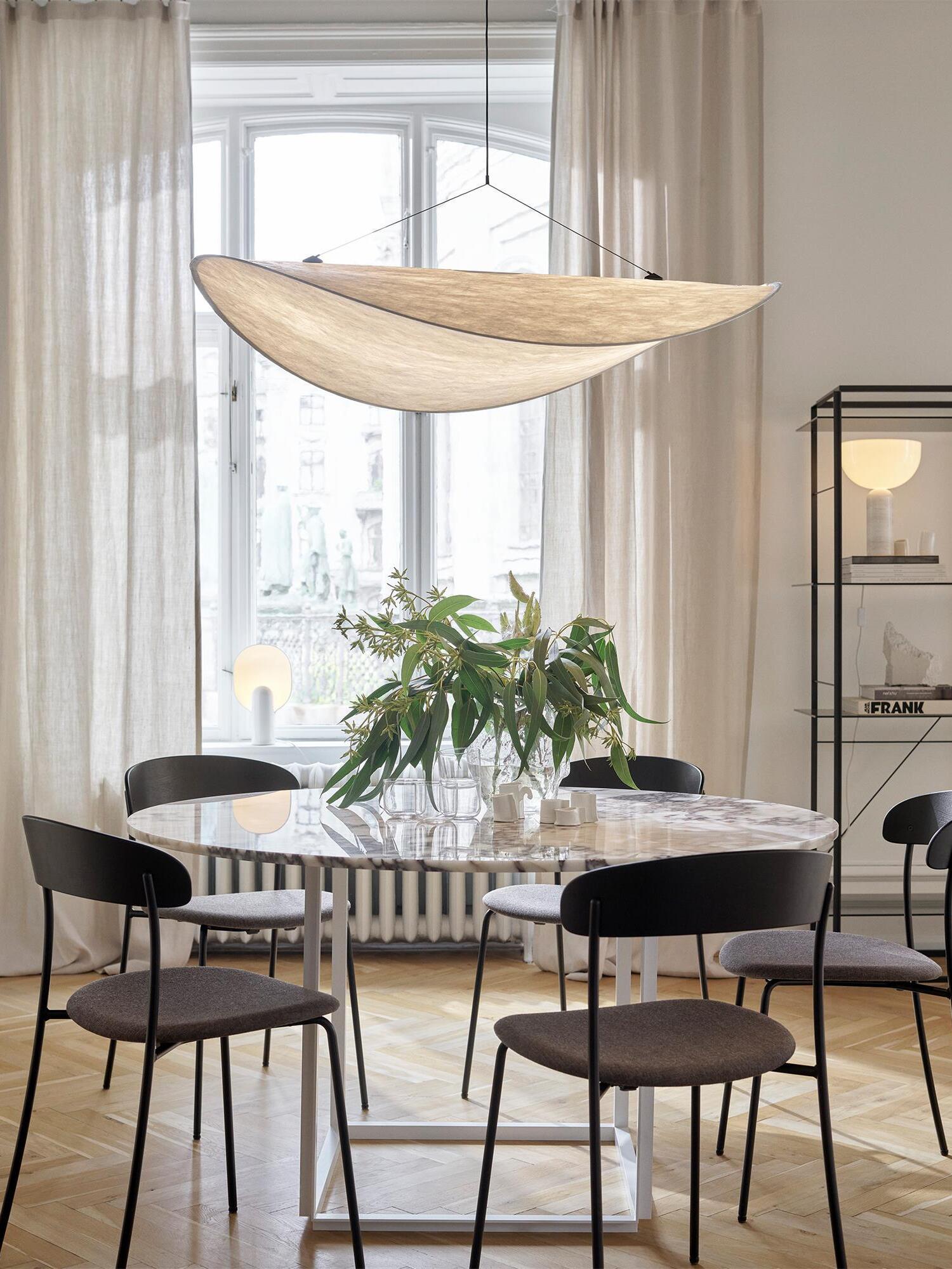 Tense pendant over a round table by a window