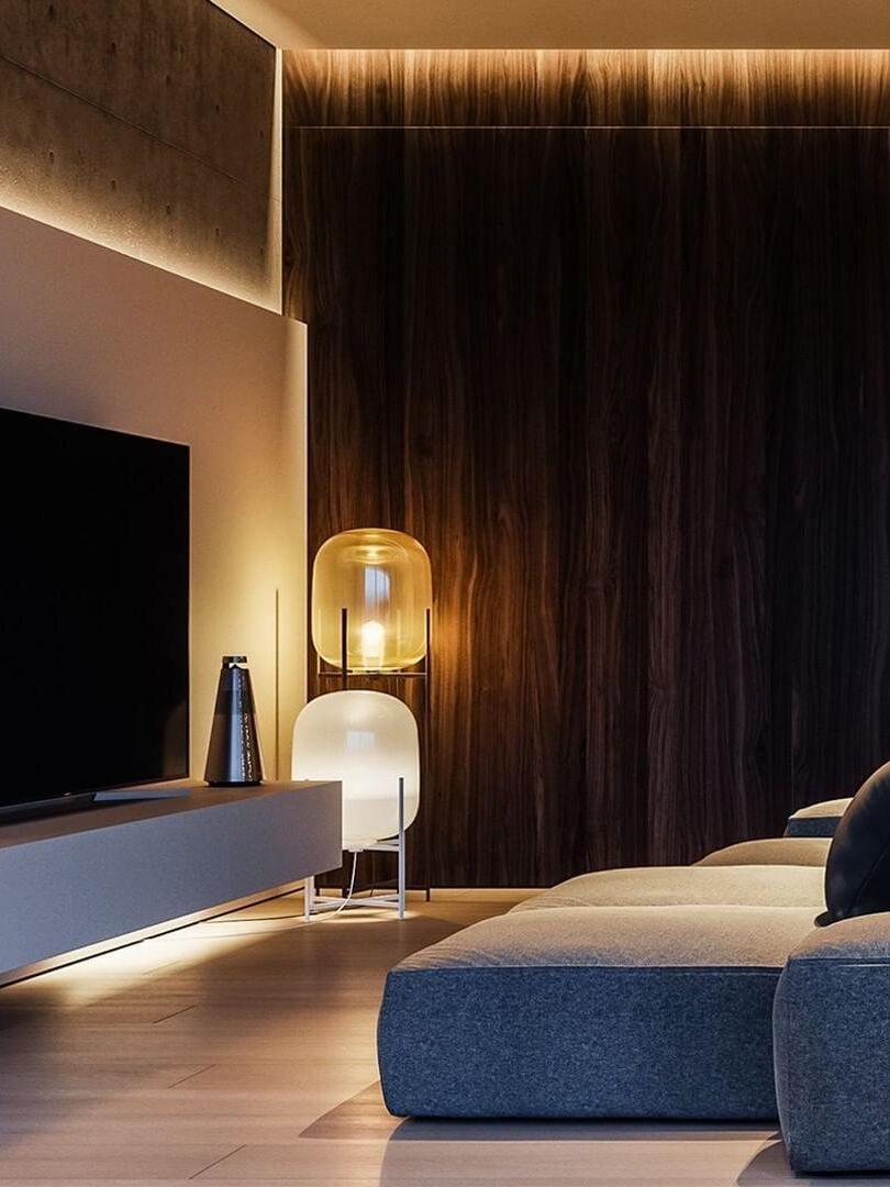 Tall amber and shorter white lamps in a dark television room.