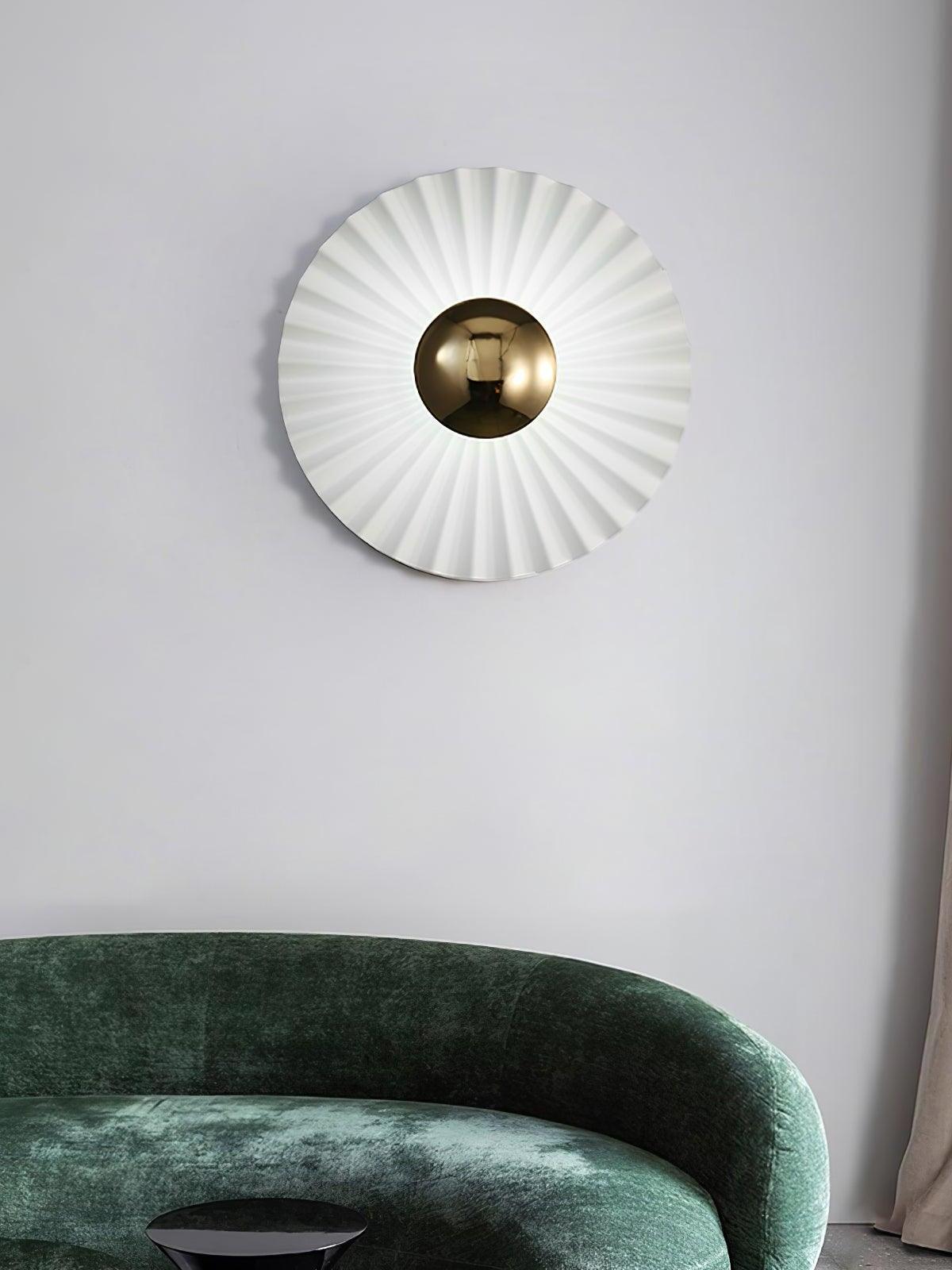 White radial wall disc above dark green sofa
