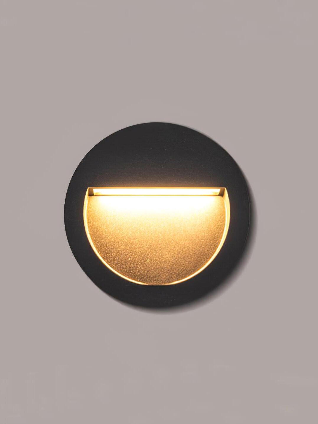 Black round half-moon wall light glowing