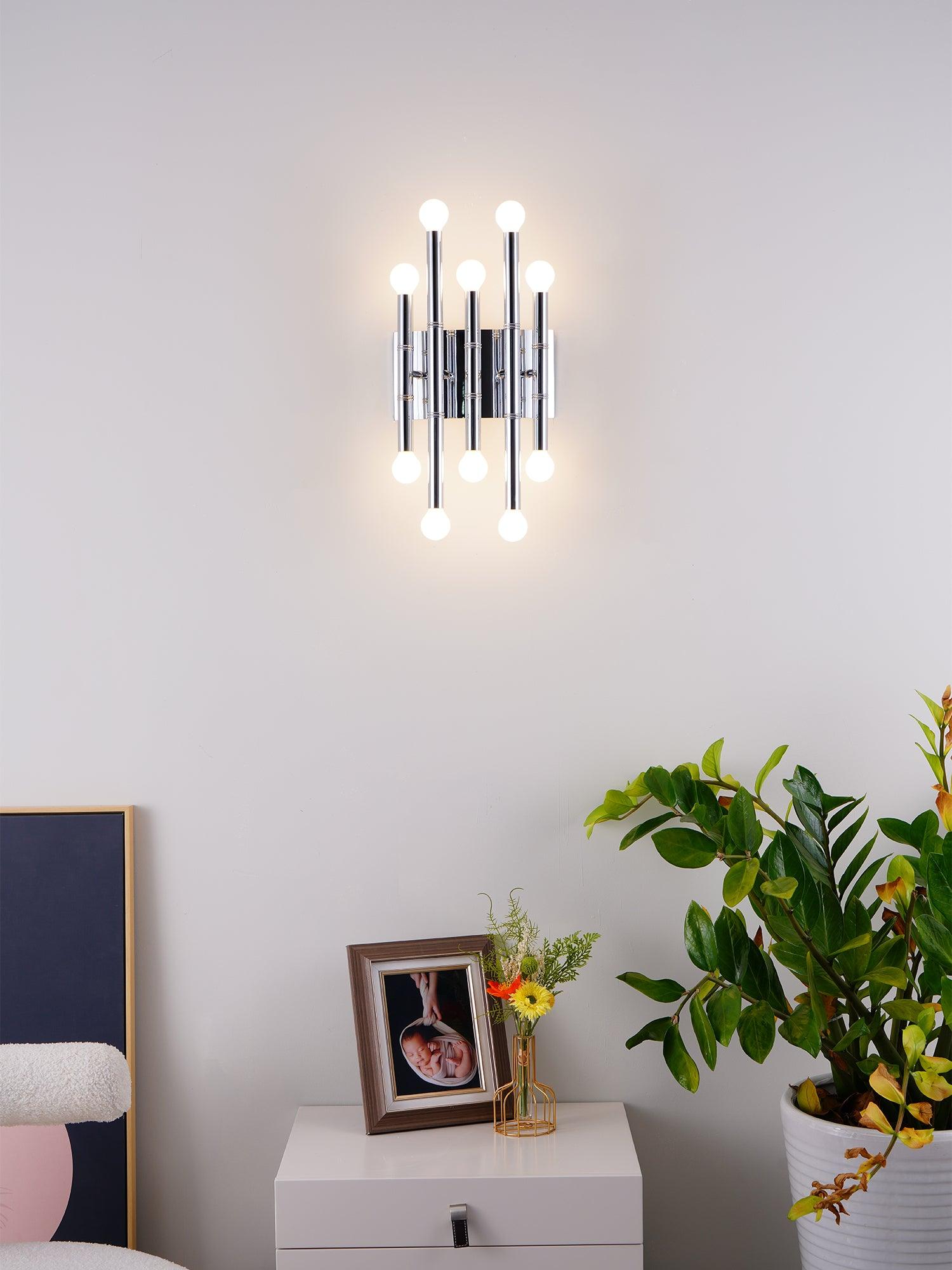 Front view of Chrome Meurice with ten glowing globes above a white cabinet, plants and a framed photo
