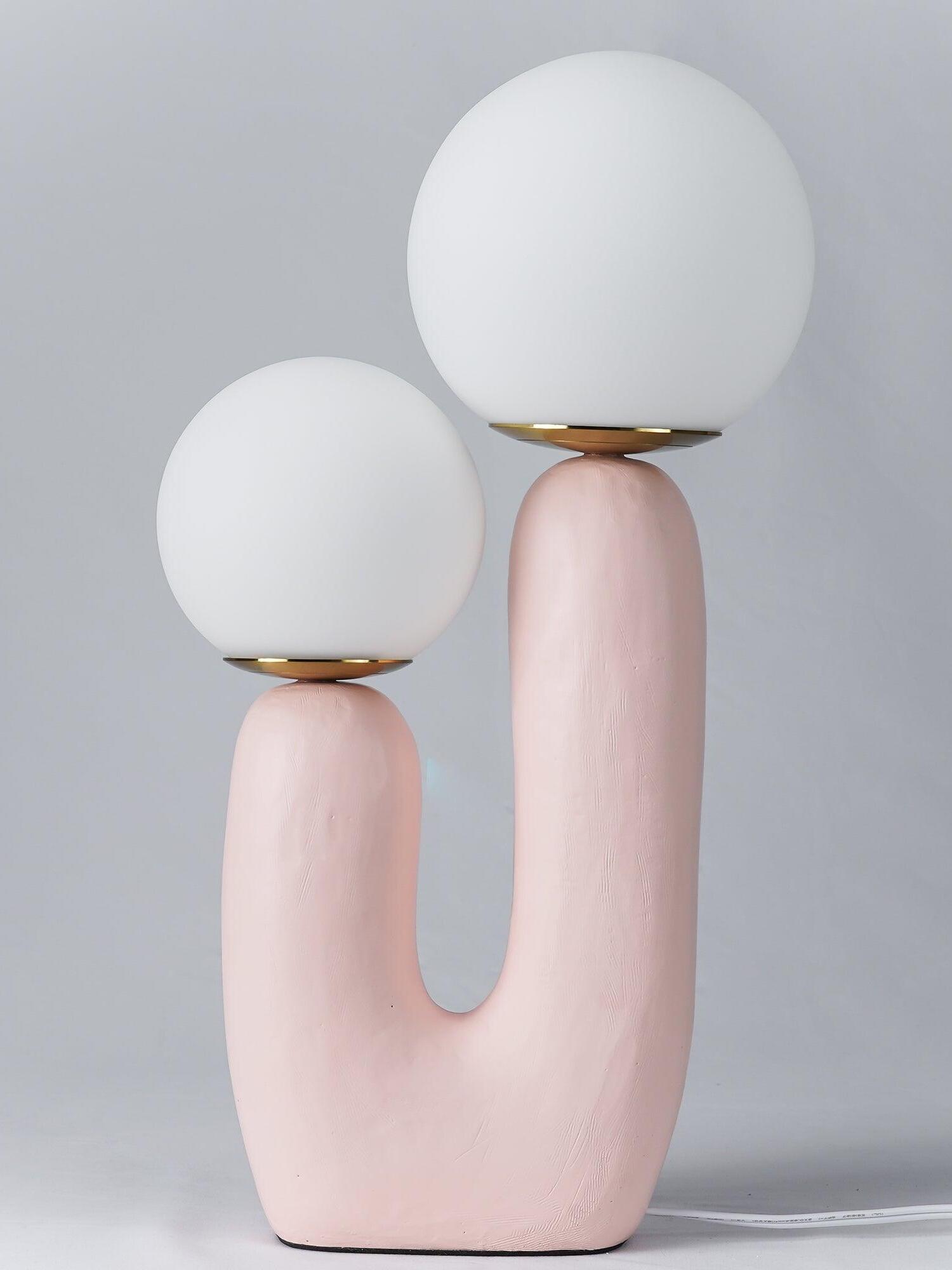Pink Oo Rough lamp against grey with unlit-looking opal globes above unequal arms and white cord to right