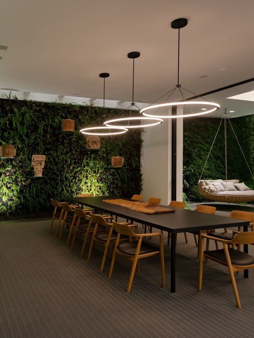 Several separately hung LED rings over long dining table