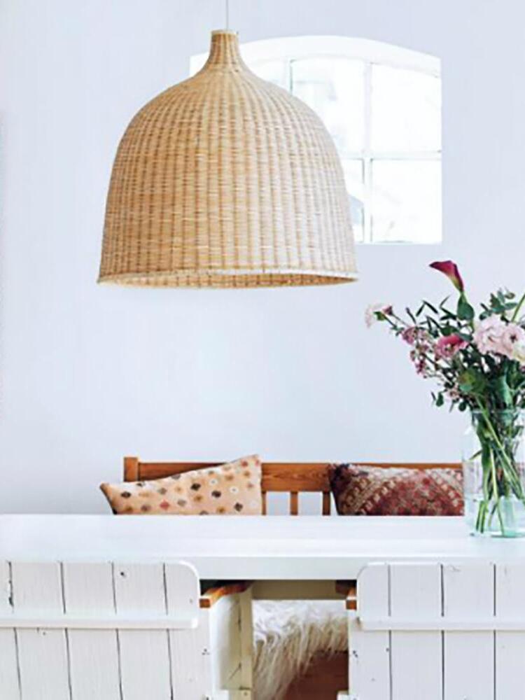Rattan pendant above a dining table by a window